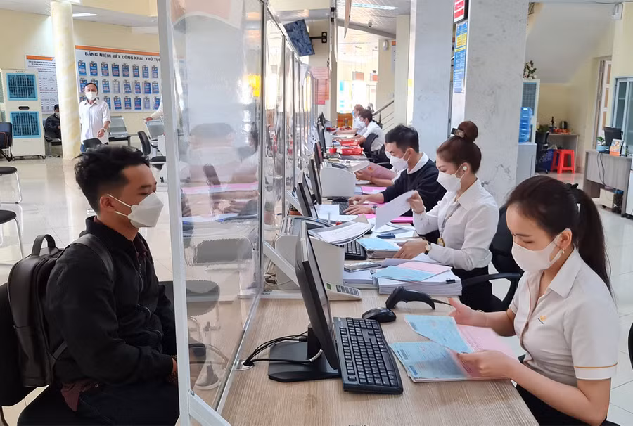 Người dân và cán bộ, công chức tại Trung tâm phục vụ hành chính công tỉnh tiếp xúc qua tấm chắn để hạn chế tối đa nguy cơ lây lan dịch bệnh. Ảnh: Văn Ngọc