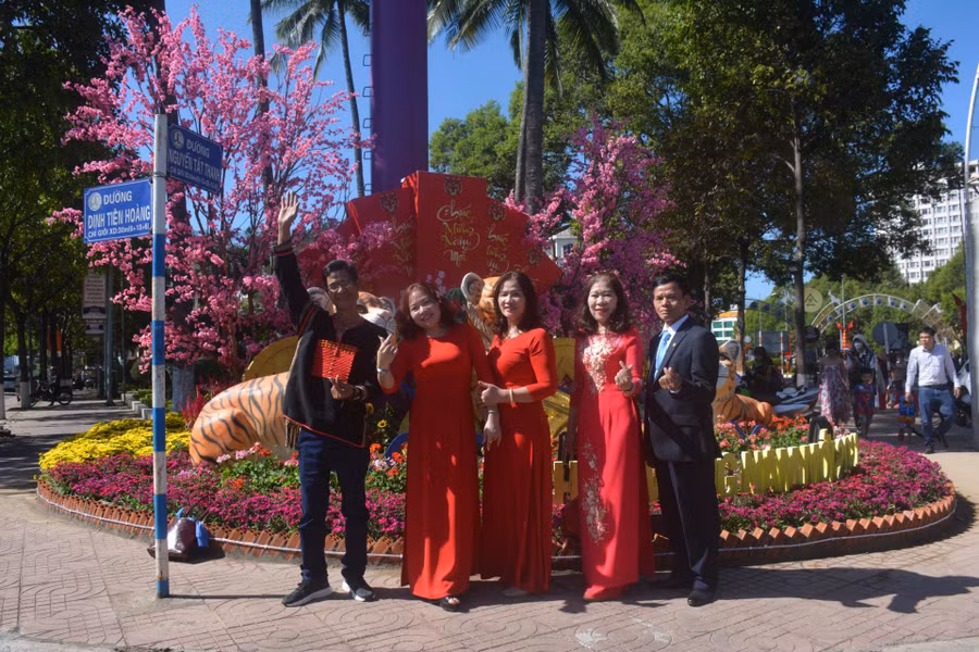  Người dân du xuân, chụp ảnh lưu niệm tại khu vực đường hoa TP. Buôn Ma Thuột. Ảnh: L.Anh