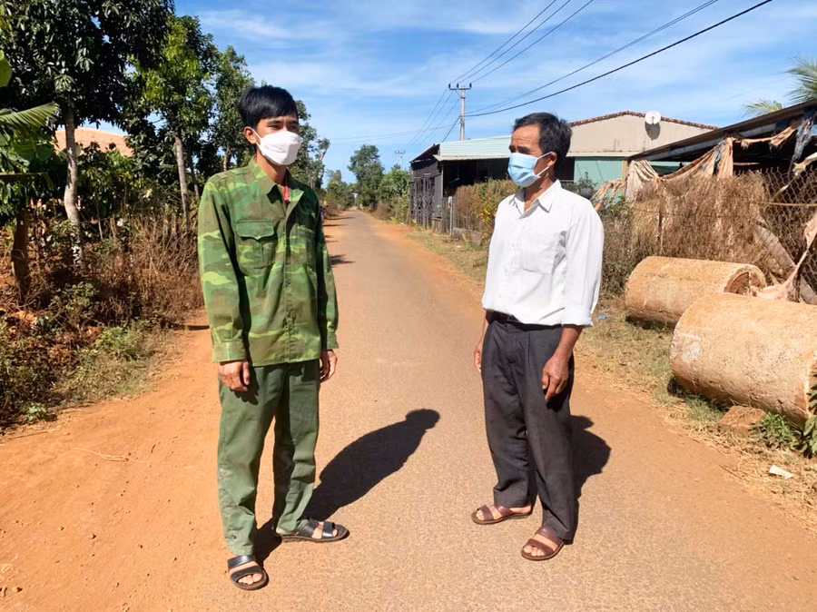 Ông Rơ Châm Jõi (bìa phải) vận động người dân phòng-chống dịch Covid-19. Ảnh: R’Ô HOK