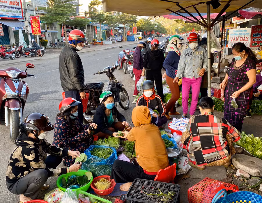 Cả người bán lẫn người mua đều tuân thủ nghiêm việc đeo khẩu trang để đảm bảo an toàn phòng dịch Covid-19. Ảnh: Mộc Trà