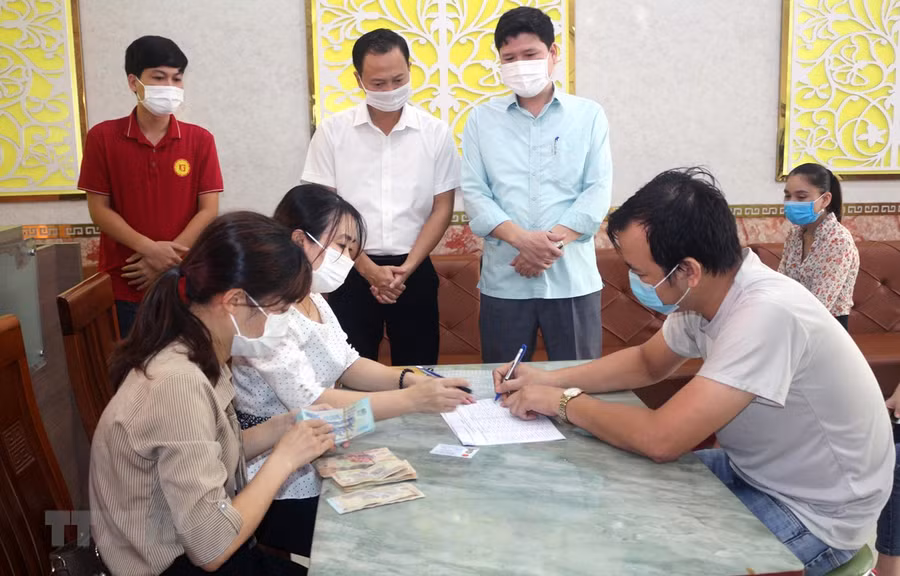  Chi trả tiền hỗ trợ cho người lao động bị ảnh hưởng bởi COVID-19. (Ảnh: Đại Nghĩa/TTXVN)