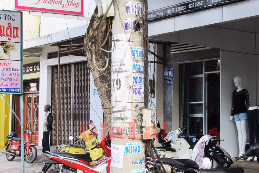 Rác quảng cáo dán đầy ở các cột điện. Ảnh: Phan Lài