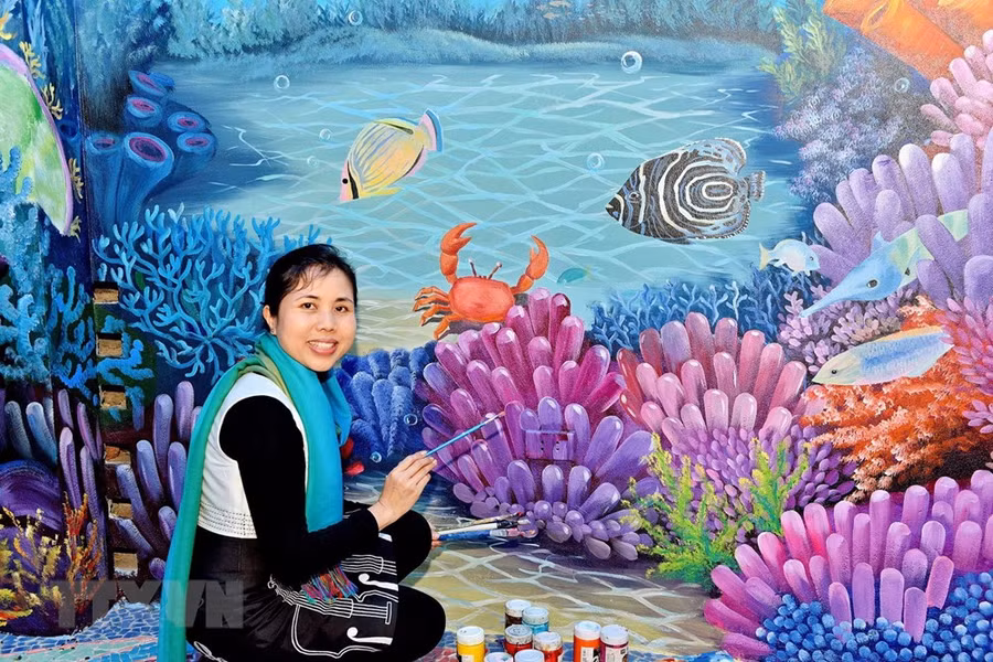 Họa sỹ Nguyễn Thu Thủy bên tác phẩm gắn gốm nghệ thuật Nhà Gương.