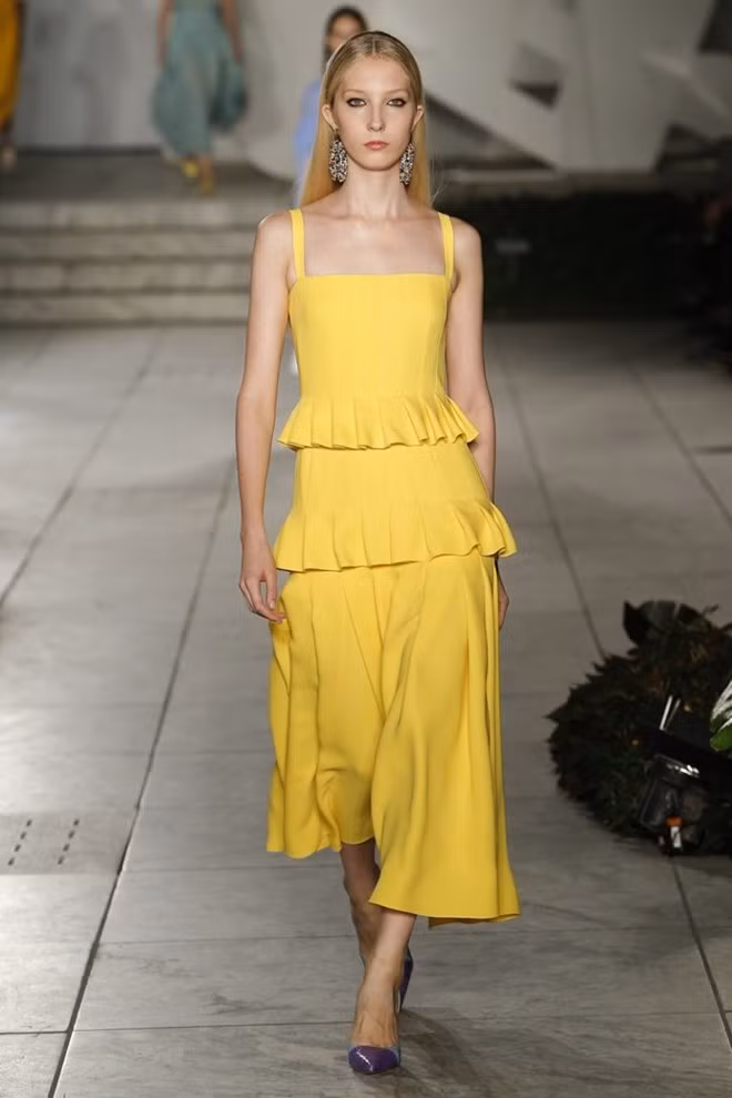  Carolina Herrera gợi nhắc tới những quý cô duyên dáng, uyển chuyển song đầy sự tự tin khi sải bước kiêu hãnh trong bộ đầm xếp tầng, cắt may tinh tế.