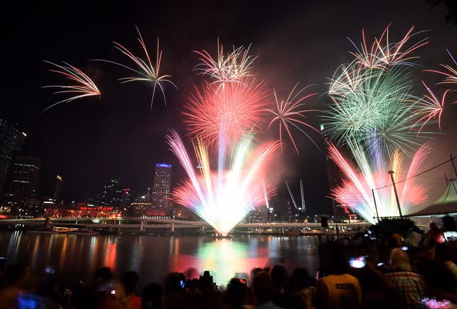 Nhiều người xem màn trình diễn bắn pháo hoa trong lễ đón Giao thừa ở thành phố Brisbane của Úc ngày 31.12 - Ảnh: Reuters