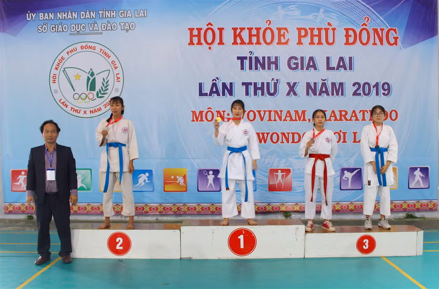 Đại diện Ban Tổ chức trao giải ở nội dung Kumite cá nhân nữ bậc THPT. Ảnh: Mộc Trà