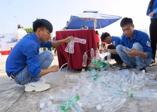 Các đoàn viên, thanh niên Đại học Quảng Bình tái chế các chai nhựa thành các vật dụng hữu ích cho cuộc sống. (Ảnh: Võ Dung/TTXVN)