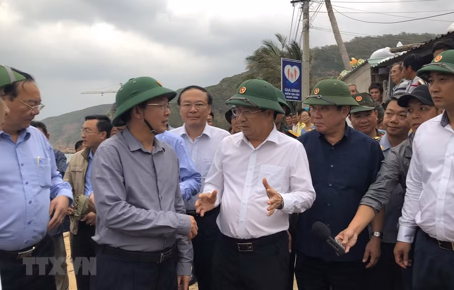  Phó Thủ tướng Trịnh Đình Dũng trao đổi với Chủ tịch Ủy ban Nhân dân tỉnh Bình Định về công tác ứng phó với bão số 6 tại xã Nhơn Hải, thành phố Quy Nhơn. (Ảnh: Nguyên Linh/TTXVN)