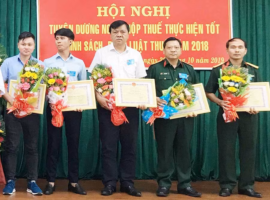  Giám đốc Công ty Bảo Việt Gia Lai (giữa) nhận giấy khen của Cục Thuế tỉnh dành cho đơn vị hoàn thành tốt nghĩa vụ thuế. Ảnh: H.D