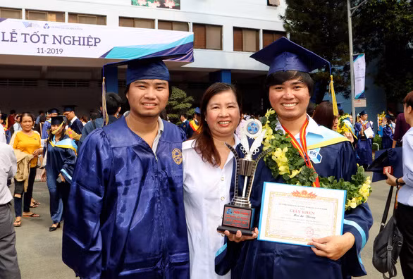 Hai tân kỹ sư Mai Lê Thái và Mai Lê Thông chụp ảnh cùng mẹ trong ngày tốt nghiệp đại học sáng nay 8-11 - Ảnh: THY HUYỀN Hai tân kỹ sư Mai Lê Thái và Mai Lê Thông chụp ảnh cùng mẹ trong ngày tốt nghiệp đại học sáng nay 8-11 - Ảnh: THY HUYỀN