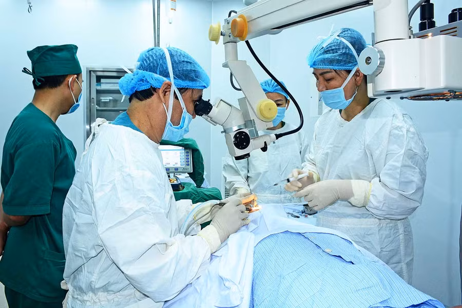  Các bác sĩ thực hiện phẫu thuật đục thủy tinh thể bằng phương pháp phaco cho bệnh nhân. Ảnh: Như Nguyện