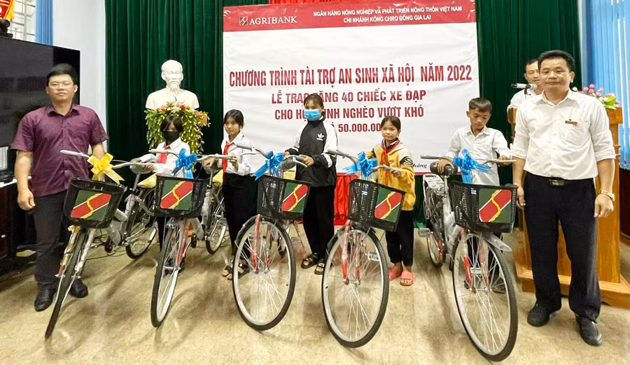 Ông Hoàng Văn Lực-Giám đốc Agribank Chi nhánh huyện Kông Chro trao tặng xe đạp cho các em học sinh. Ảnh: Lê Liên