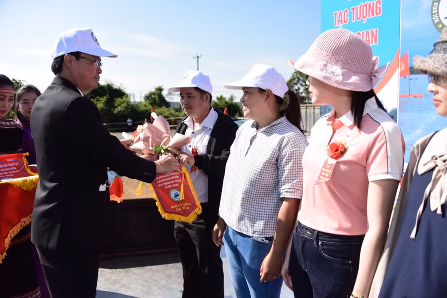 Ông Lê Ngọc Quý-Chủ tịch UBND huyện Ia Grai-trao cờ cho các đoàn tham gia Hội đua thuyền độc mộc trên sông Pô Cô lần thứ III. Ảnh: Đức Thụy