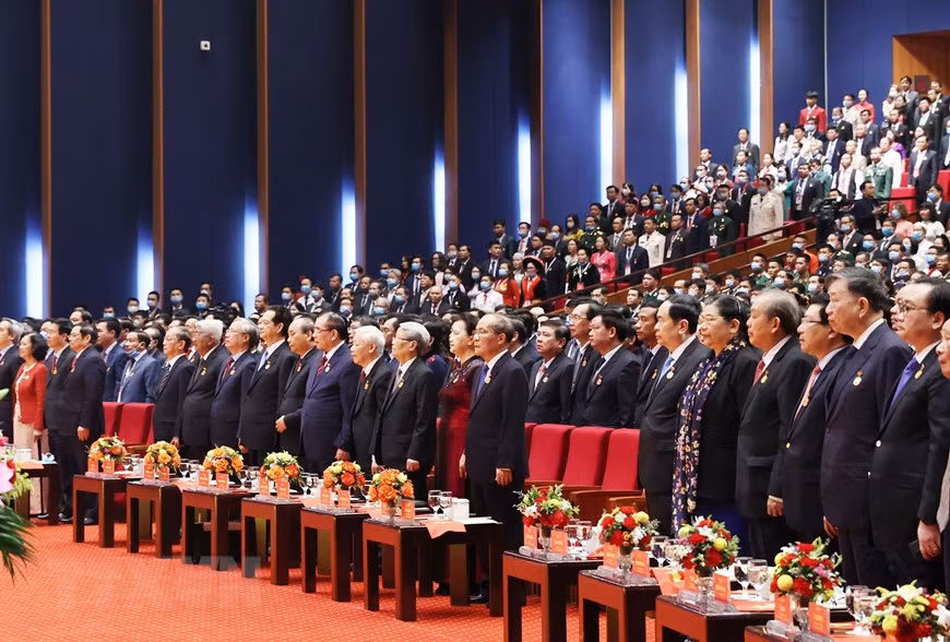Các vị lãnh đạo, nguyên lãnh đạo Đảng Nhà nước cùng các đại biểu thực hiện nghi lễ chào cờ. (Ảnh: Thống Nhất/TTXVN)