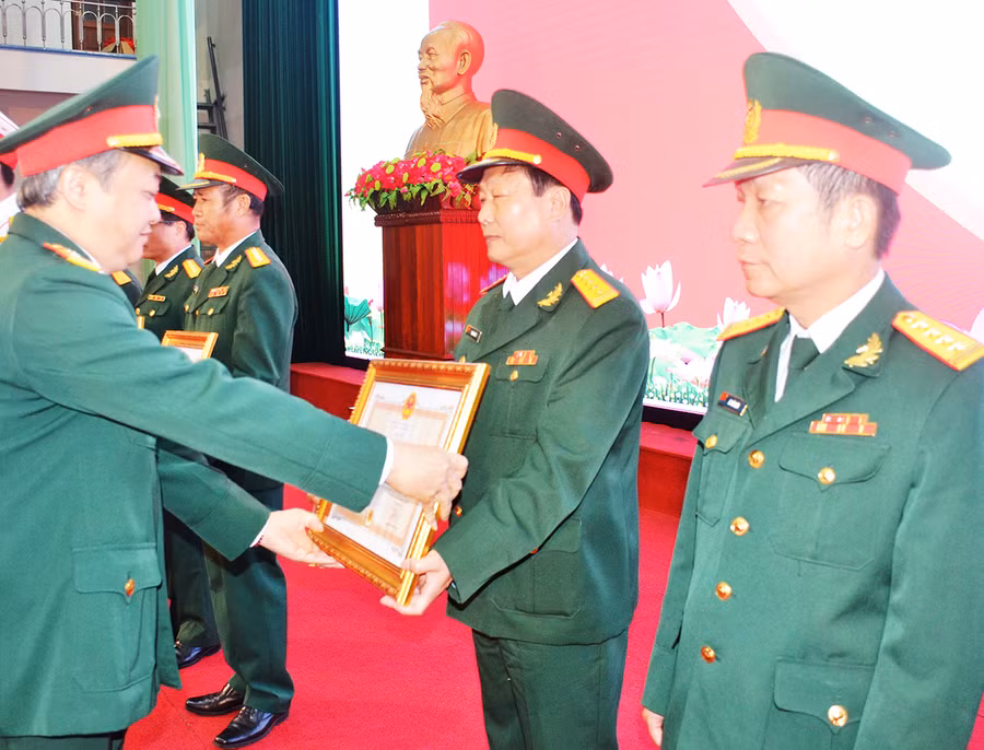 Thừa ủy quyền của Chủ tịch Nước, Đại tá Hoàng Văn Sỹ trao Huân chương Bảo vệ Tổ quốc cho các đồng chí nguyên lãnh đạo các cơ quan, đơn vị. Ảnh: Vĩnh Hoàng