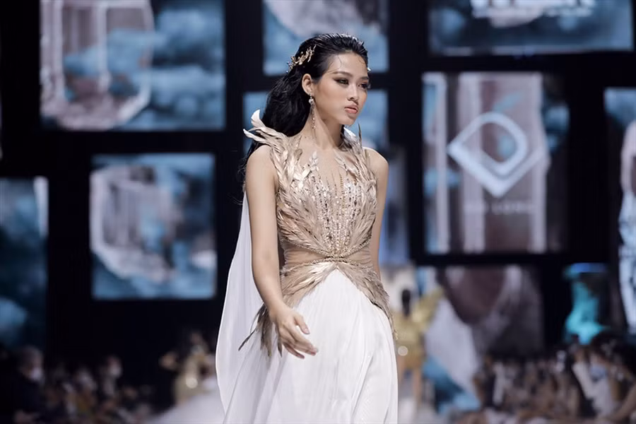 Hoa hậu Đỗ Thị Hà sải bước với thần thái đầy tự tin trong thiết kế gắn lông vũ, có đường cut-out tinh tế ở vùng eo. Mẫu váy thuộc bộ sưu tập 