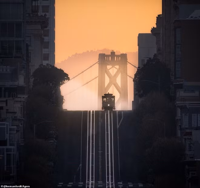 Để chụp được bức ảnh bình minh tuyệt đẹp ở San Francisco này, nhiếp ảnh gia Lee Mumford đã phải thức dậy trước khi mặt trời ló dạng. Lee giải thích: “Tôi bất ngờ với vận may của mình khi mọi thứ bắt đầu xuất hiện vào đúng vị trí. Ánh sáng hoàn hảo, chiếc xe điện mang tính biểu tượng, con đường thẳng tắp, cầu Vịnh Oakland và màn sương mù ấn tượng”.