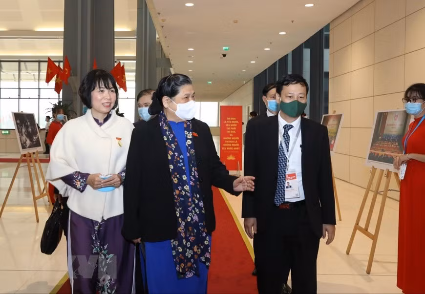 Lãnh đạo Thông tấn xã Việt Nam giới thiệu với Phó Chủ tịch Thường trực Quốc hội Tòng Thị Phóng những hình ảnh của TTXVN trưng bày tại Đại hội. (Ảnh: Văn Điệp/TTXVN)