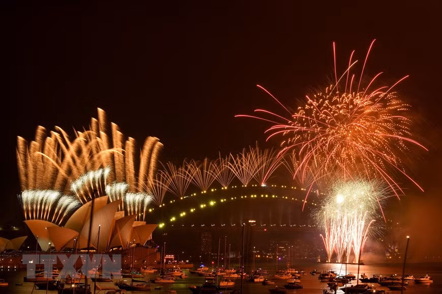 Tại Australia, các thành phố phía Đông gồm Melbourne, Sydney và Canberra sẽ là những nơi đón 2021 đầu tiên ở nước này. Năm nay màn pháo hoa ngoạn mục mừng Năm mới tại thành phố Sydney đã phải thu nhỏ quy mô đáng kể do dịch COVID-19. Ảnh: Pháo hoa mừng Năm mới rực rỡ trên cầu cảng Sydney. (Ảnh: AFP/TTXVN)