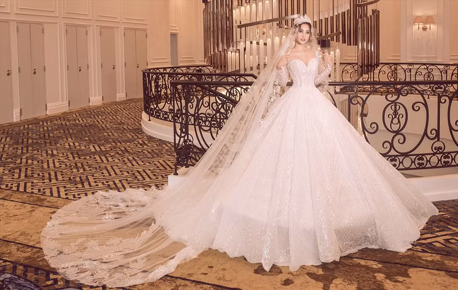 Tiểu Vy trong đầm trắng dáng corset tôn vòng một. Phần thân váy đính sequin tạo hiệu ứng bắt sáng.