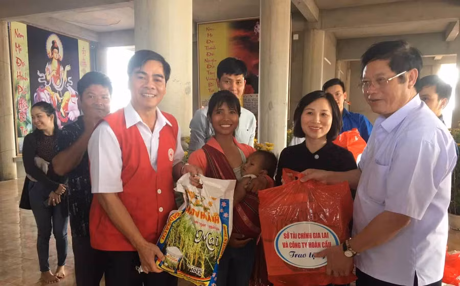 	Lãnh đạo Sở Tài chính, Hội Chữ thập đỏ tỉnh tặng quà cho đồng bào nghèo. Ảnh: Hồng Ngọc 