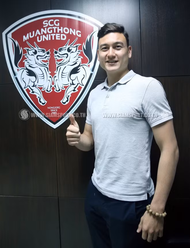 Văn Lâm chụp ảnh kỷ niệm bên cạnh logo đội bóng mới. Ảnh: Siam Sport.