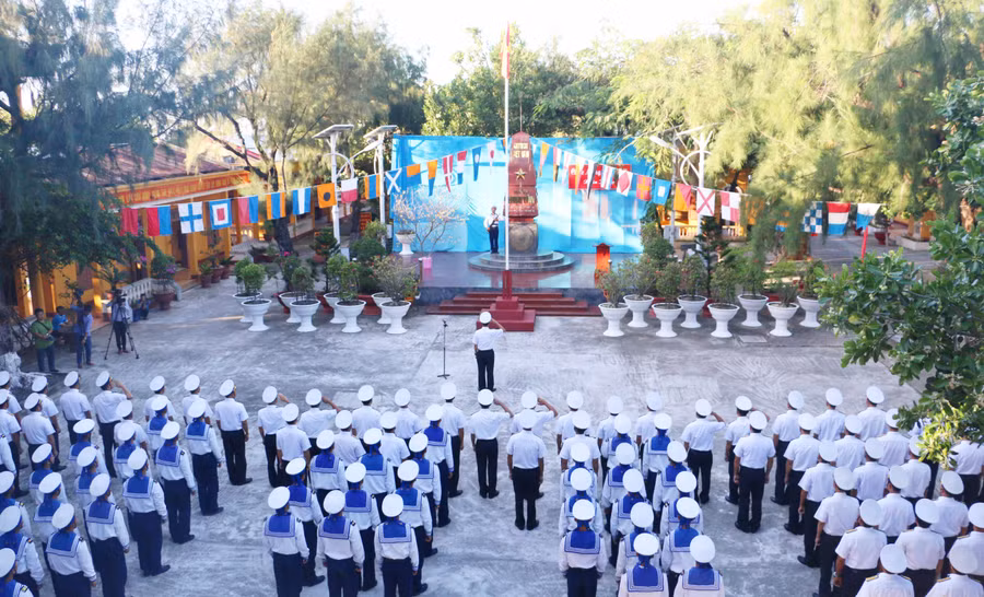 Các bộ, chiến sĩ và nhân dân đảo Sinh Tồn thực hiện nghi lễ chào cờ đầu năm mới. Ảnh: Quang Tấn