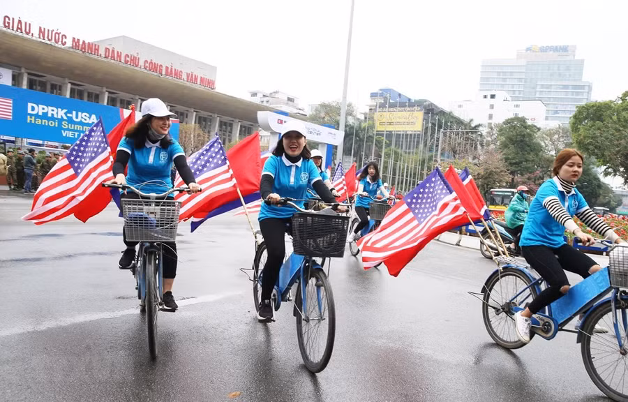  Thiếu nữ Việt Nam diễn hành Đạp xe vì Hòa bình với quốc kỳ Việt Nam và hai nước Mỹ, Triều Tiên trên đường Trần Hưng Đạo, Hoàn Kiếm. (Ảnh: Lâm Khánh/TTXVN)