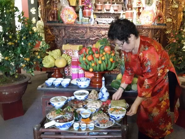 Nghệ nhân Ánh Tuyết với mâm cỗ Tết truyền thống Hà Nội. (Ảnh: Đinh Thị Thuận/TTXVN)