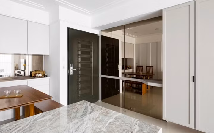 Bức tường bằng kính đặt giữa phòng khách và nhà bếp để tăng cảm giác rộng rãi cho không gian.