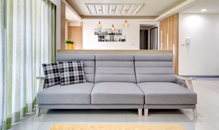 Ghế sofa thấp mang đến một không gian tiếp khách thoải mái mà vẫn không cản đường đi của ánh sáng.