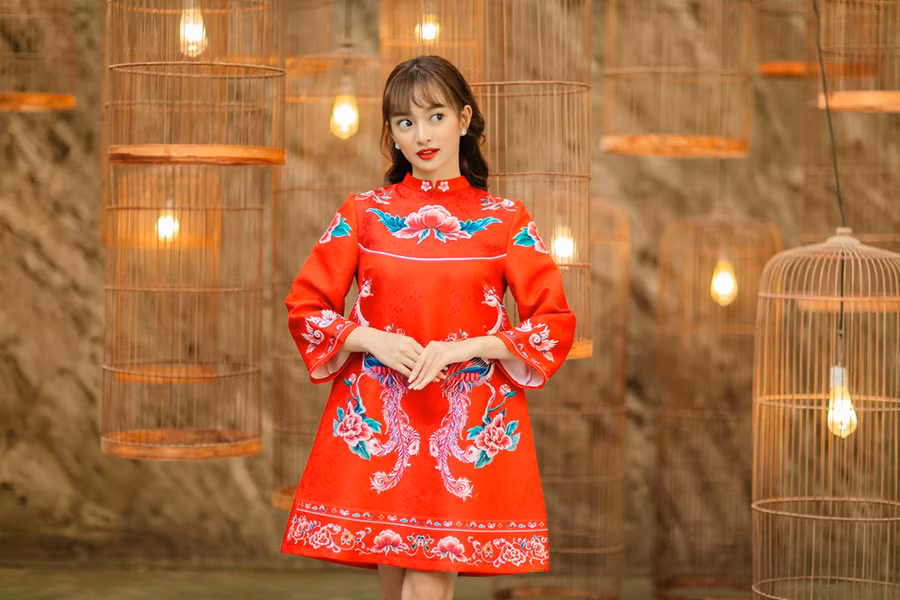 Mỗi năm lại có thêm nhiều mẫu áo dài cách tân và Kaity Nguyễn cũng chọn phong cách này cho bộ ảnh đón Tết. Cô diện áo dài đỏ không ôm dáng, chân váy ngắn và họa tiết rực rỡ.