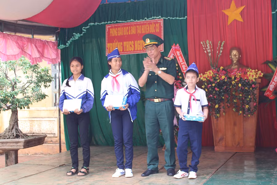  Đại tá Trần Trung Dũng-Phó Chỉ huy trưởng Bộ Chỉ huy Bộ đội Biên phòng tỉnh trao tiền và quà cho các em học sinh. Ảnh: Anh Huy