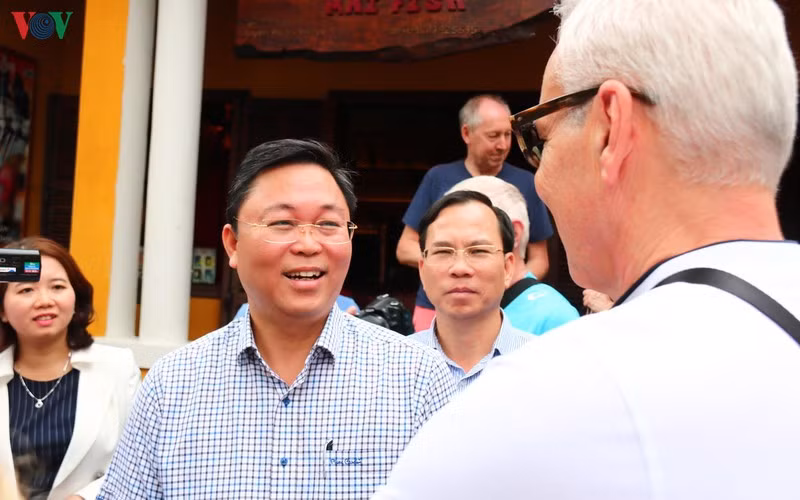 Ông Lê Trí Thanh (áo kẻ) xuống phổ nói chuyện với khách du lịch về điểm đến an toàn Hội An.