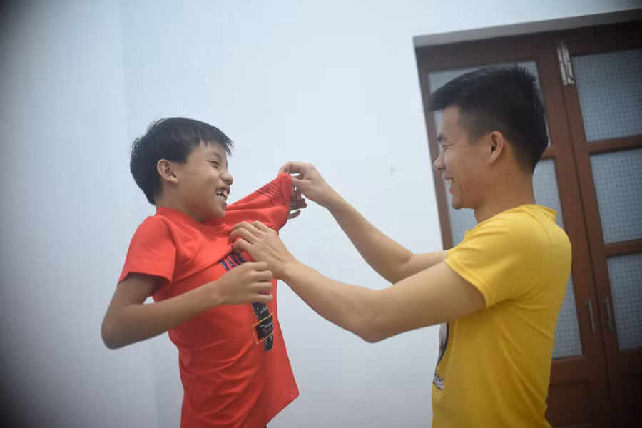 Trung úy Cao Đại Đồng tự tay mua tặng cho Thanh đồ mới để động viên Thanh cố gắng học tập. Thanh tỏ ra rất bất ngờ và vui mừng - Ảnh: LÂM THIÊN