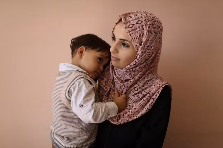 Một phụ nữ Palestine bế một đứa trẻ tại trung tâm y tế của Cơ quan Cứu trợ và Công trình của Liên Hợp Quốc dành cho người tị nạn Palestine ở Cận Đông, trong trại Rafah ở phía nam Dải Gaza, ngày 3.9.2019. Ảnh: Reuters 