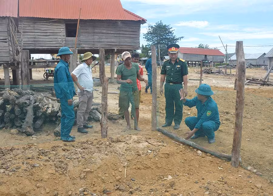 Lực lượng vũ trang huyện Phú Thiện hướng dẫn người dân làng Trớ làm hàng rào, vườn rau. Ảnh: A.H