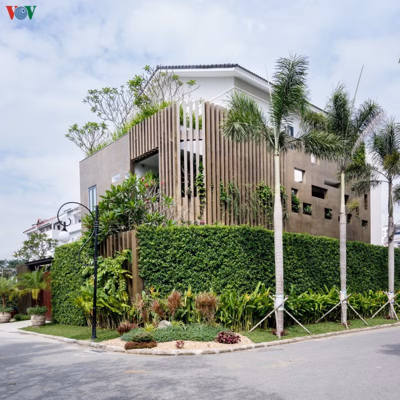 Ngôi nhà nằm ở góc đường, có diện tích vừa phải. Từ bên ngoài, công trình gợi nên cảm giác thân thiện với hàng rào cây xanh. Hệ lam chắn nắng màu nâu trầm cũng là điểm nhấn gây chú ý.