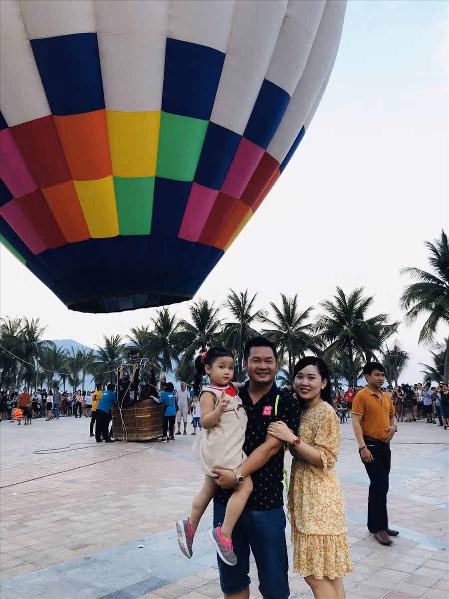  Một gia đình khách du lịch tranh thủ chụp ảnh lưu niệm với khinh khí cầu.