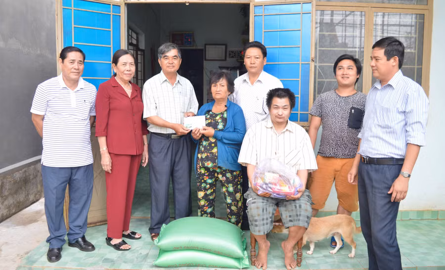Hội đồng hương huyện Mộ Đức-Quảng Ngãi hỗ trợ cho bà Xi quà và 12 triệu đồng tiền mặt. Ảnh: Đinh Yến