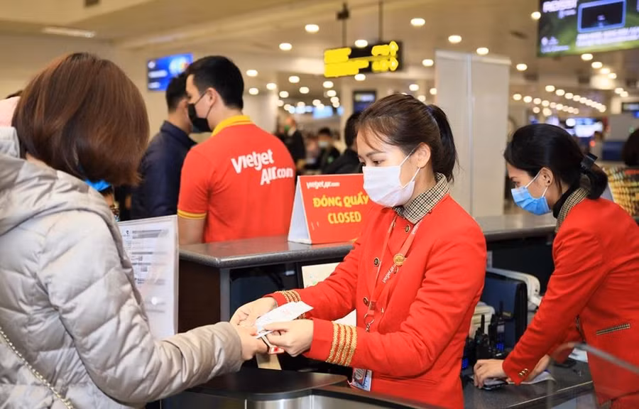  Hành khách làm thủ tục lên chuyến bay của hãng hàng không Vietjet. (Ảnh: CTV/Vietnam+)