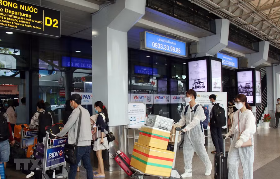 Để phòng chống dịch, nhiều hành khách đã chủ động trang bị các bộ đồ bảo hộ khi đến sân bay Tân Sơn Nhất. (Ảnh: Tiến Lực/TTXVN)