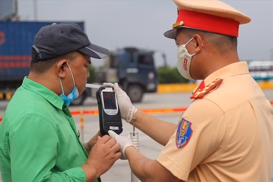  Cảnh sát giao thông thực hiện kiểm tra nồng độ cồn với lái xe. Ảnh MH