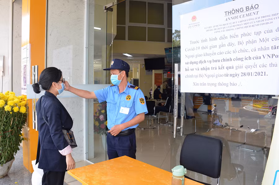 Người dân đến liên hệ công việc tại Trung tâm Phục vụ hành chính công đều phải đo thận nhiệt, rửa tay sát khuẩn. Ảnh: Vĩnh Hoàng