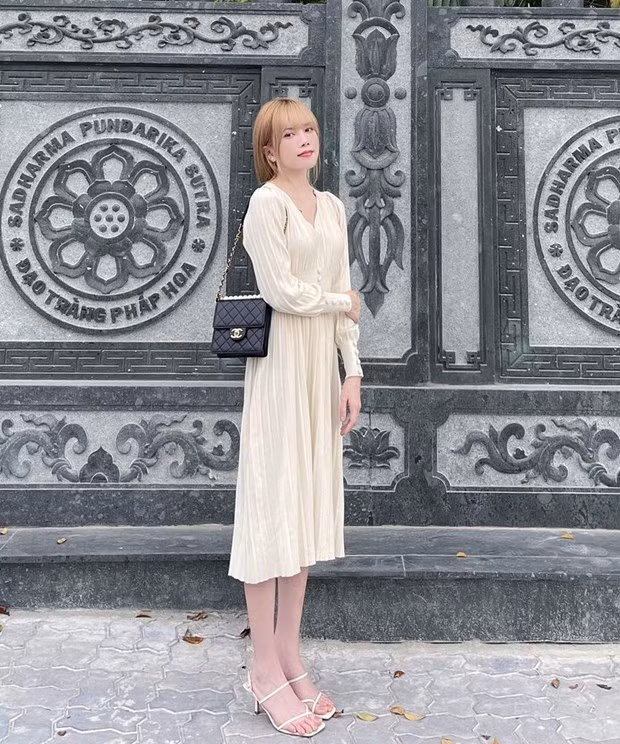  Đầm trắng thắt eo và sandals tiệp màu, điểm túi Chanel nhỏ, giúp Thiều Bảo Trâm làm bật vẻ dịu dàng.