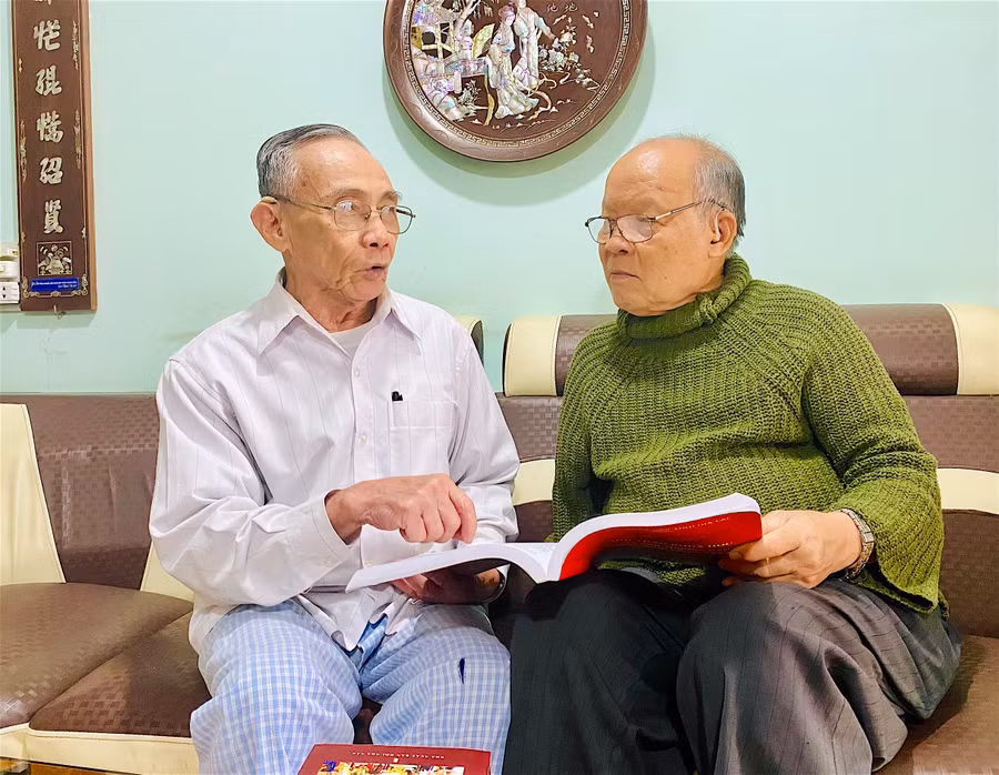 Ông Nguyễn Quốc Thành (bìa phải; phường Tây Sơn, thị xã An Khê) nhắc nhớ về quá trình điền dã tìm hiểu việc chuẩn bị khởi nghĩa của anh em nhà Tây Sơn trên đất An Khê xưa. Ảnh: Hồng Thi