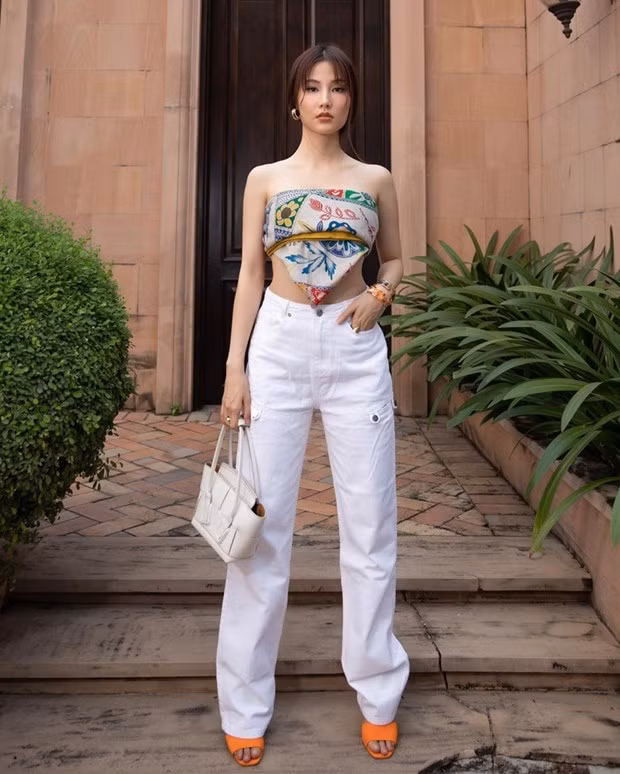 Diễm My 9X ''dát'' hàng hiệu du xuân. Nữ diễn viên biến khăn họa tiết thành áo, phối cùng quần jeans trắng và sandals màu cam bắt mắt.