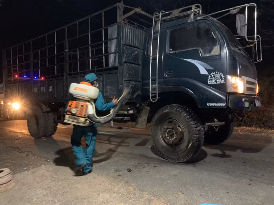 Lực lượng chức năng phun thuốc khử khuẩn phương tiện đi qua chốt kiểm soát. Ảnh: Vũ Chi Cán bộ, chiến sĩ phun thuốc khử khuẩn cho phương tiện đi qua chốt kiểm soát. Ảnh.Vũ Chi