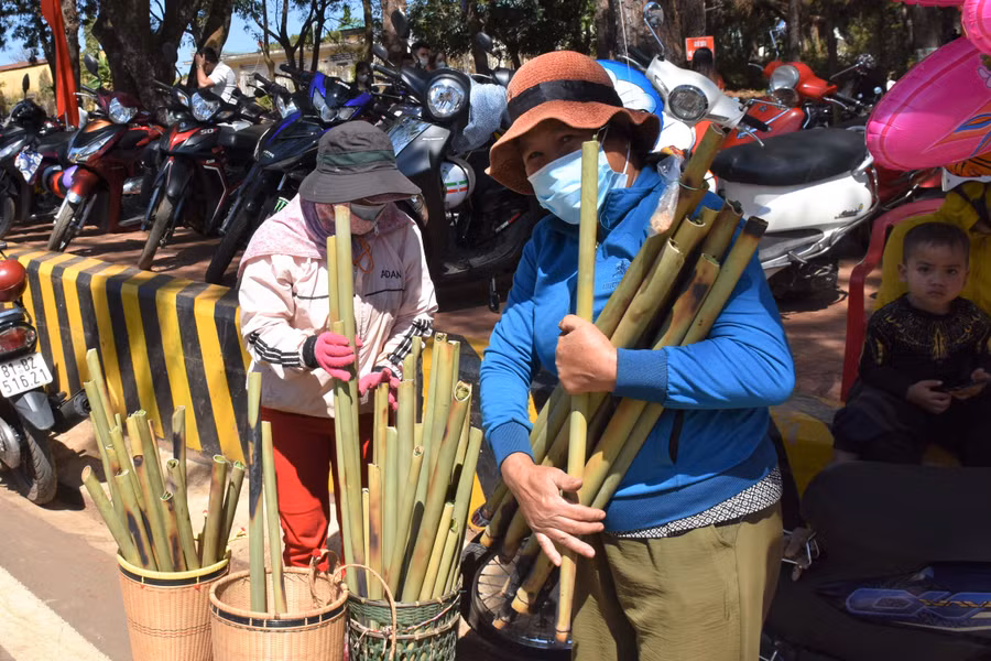 Phụ nữ Jrai gùi cơm lam phục vụ khách du xuân tại Khu du lịch Biển Hồ. Ảnh: Trần Dung
