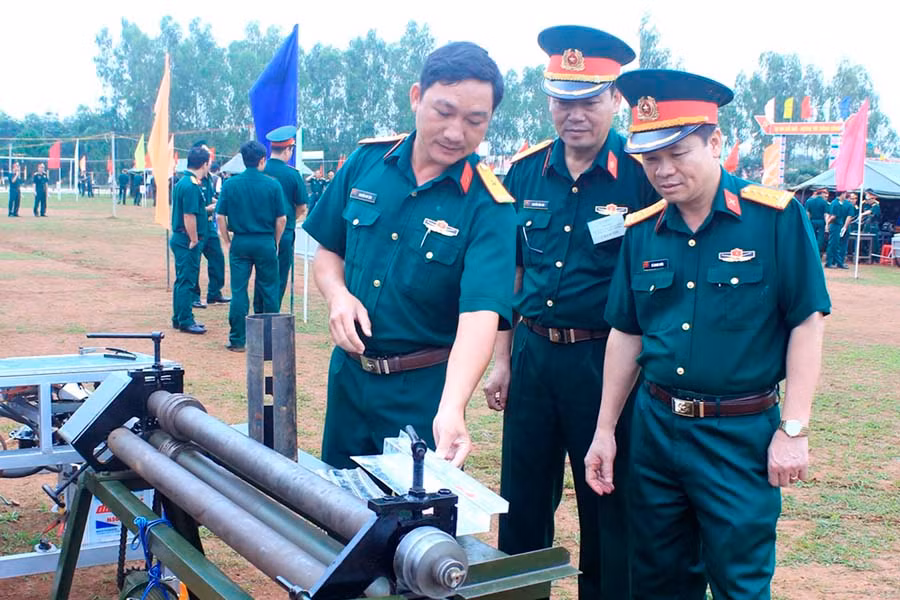  Thiếu tá Nguyễn Duy Tân (thứ 3 từ phải sang) đang giới thiệu sáng kiến “Máy uốn ép tôn đa năng”. Ảnh: V.D.H